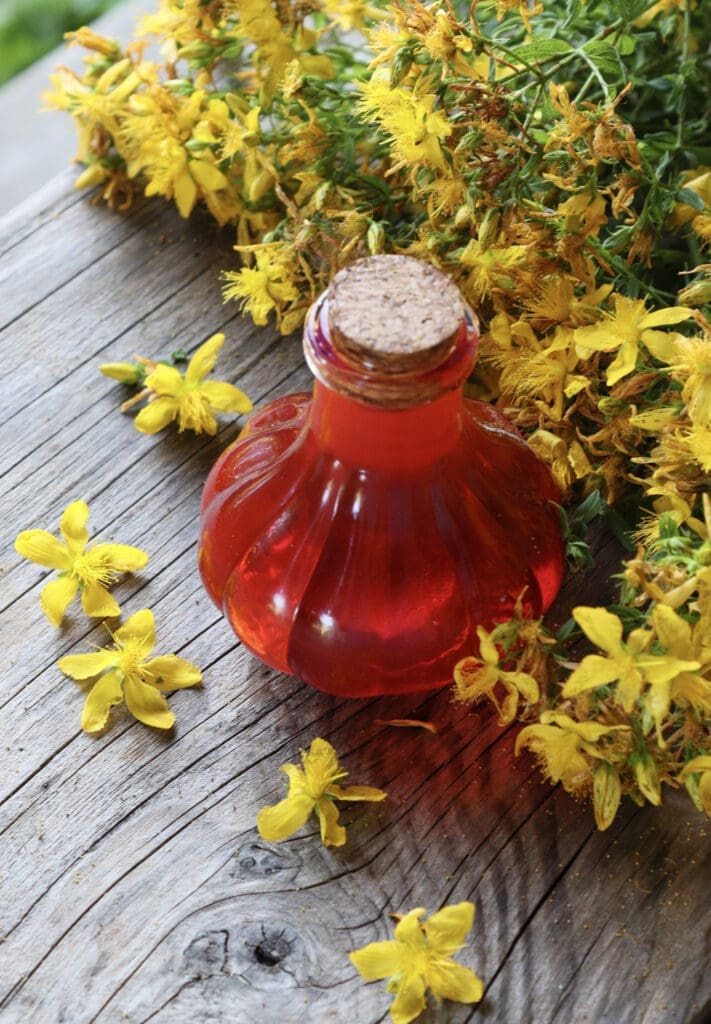 Image of hypericum oil with st. john's wort flowers in the background